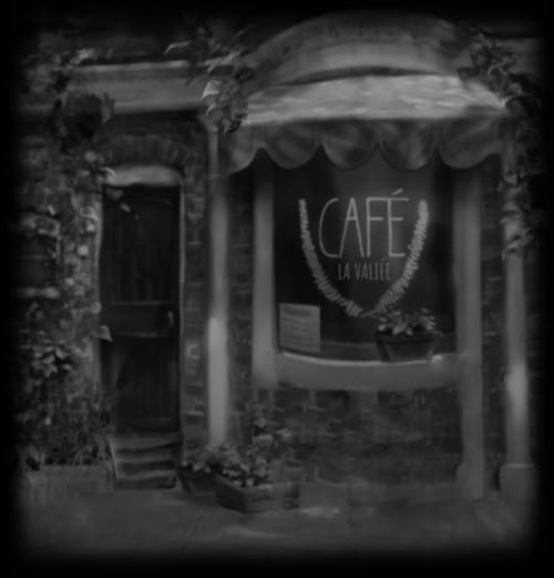 A little cafe outside with a table and chairs in front of a window. A chalkboard outside has an interesting quote